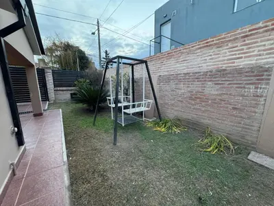 a swing in a yard next to a brick wall at Casa Paz in Villa Carlos Paz
