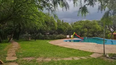 a swimming pool with a slide in a park at Las Casitas, cabañas & suites in Pincén
