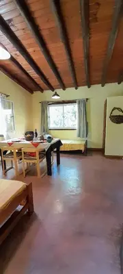 a living room with a table and a bed at Las Casitas, cabañas & suites in Pincén