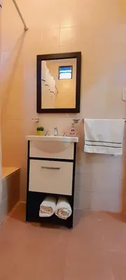 a bathroom with a sink and a mirror at Las Casitas, cabañas & suites in Pincén