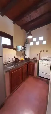 a kitchen with a sink and a stove at Las Casitas, cabañas & suites in Pincén
