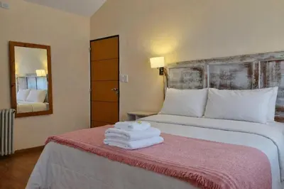 a hotel room with a bed with towels on it at Posada Faro Serrano in Villa General Belgrano