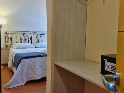 a bedroom with a bed with blue pillows at Posada Faro Serrano in Villa General Belgrano