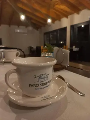 a coffee cup on a plate on a table at Posada Faro Serrano in Villa General Belgrano