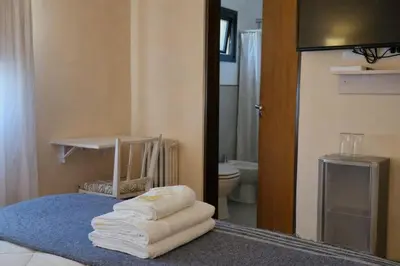 a bathroom with a bed with towels on it at Posada Faro Serrano in Villa General Belgrano
