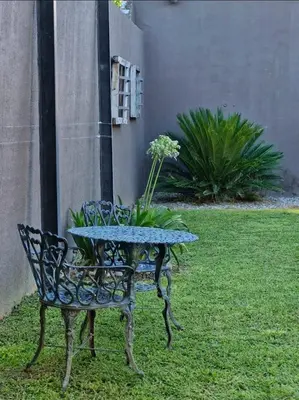 a table and a bench with a table and flowers at Posada Faro Serrano in Villa General Belgrano