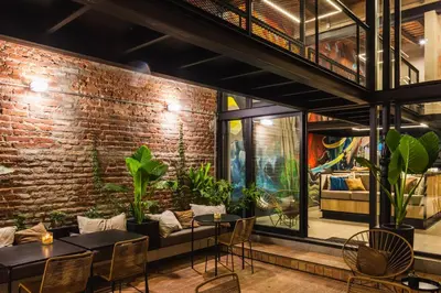 a restaurant with tables and chairs and a brick wall at Faz Hostel Boutique in Cordoba