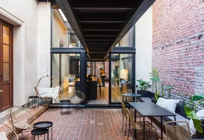a patio with tables and chairs and a brick wall at Faz Hostel Boutique in Cordoba
