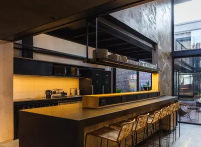 a kitchen with a large counter with stools at Faz Hostel Boutique in Cordoba