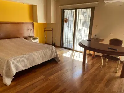 a bedroom with a bed and a desk and a table at categoria a 1 cuadra plaza espana in Cordoba
