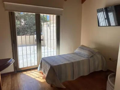 a bedroom with a bed and a sliding glass door at categoria a 1 cuadra plaza espana in Cordoba