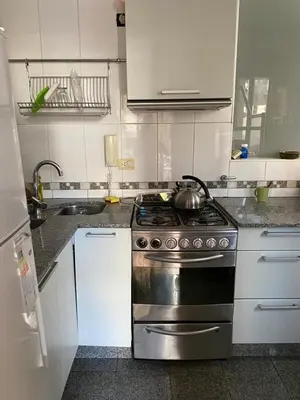 a kitchen with a stainless steel stove and white cabinets at categoria a 1 cuadra plaza espana in Cordoba