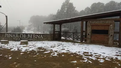 a sign in the snow in front of a building at LA LINDA - Cabaña de Montaña in Villa Berna