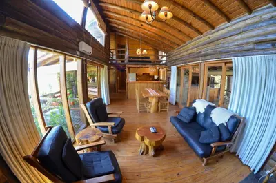 a living room with a couch and chairs and a table at LA LINDA - Cabaña de Montaña in Villa Berna