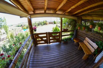 a wooden deck with a bench and some plants at LA LINDA - Cabaña de Montaña in Villa Berna