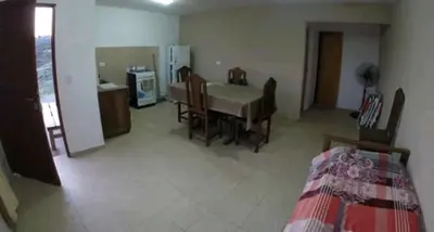 a living room with a table and chairs and a kitchen at Vista del Lago in Villa Carlos Paz