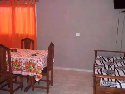 a dining room with a table and chairs and a bed at Vista del Lago in Villa Carlos Paz