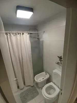 a white bathroom with a shower and a toilet at Cofico Ideal in Cordoba