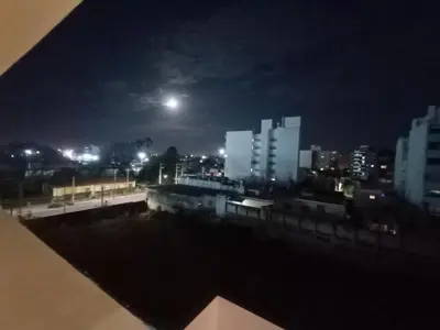 a view of a city at night with the moon at Cofico Ideal in Cordoba