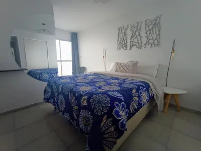 a bedroom with a bed with a blue and white comforter at Cofico Ideal in Cordoba
