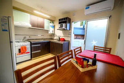 a small kitchen with a table and a red table sidx sidx sidx sidx at Estrella de Mar in Villa Carlos Paz
