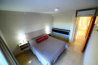 a bedroom with a bed with a red pillow on it at Estrella de Mar in Villa Carlos Paz