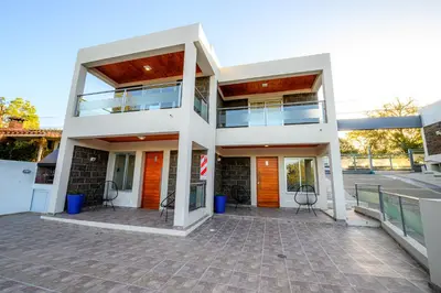 a large white building with chairs in front of it at Estrella de Mar in Villa Carlos Paz