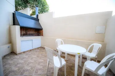 a patio with a table and chairs and a fireplace at Estrella de Mar in Villa Carlos Paz