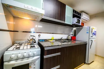 a kitchen with a white stove and a refrigerator at Estrella de Mar in Villa Carlos Paz