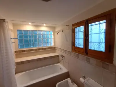 a bathroom with a tub and a toilet and a window at Casa Lucerna in Cordoba
