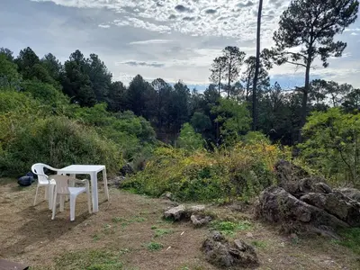 a white table and chairs sitting on top of a field at Espejo de Hadas - Terrafirme in Villa Yacanto