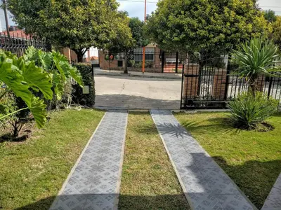 a walkway in a park with a fence at Cabañas Bosque in Villa Carlos Paz