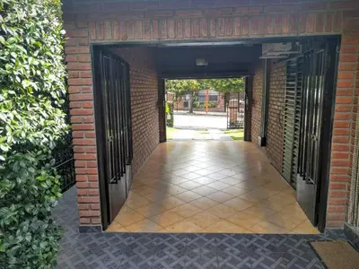 an open door into a brick building with a walkway at Cabañas Bosque in Villa Carlos Paz