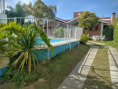 a fence around a swimming pool in a yard at Cabañas Bosque in Villa Carlos Paz