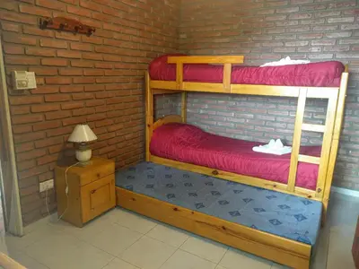 a room with two bunk beds in a brick wall at Cabañas Bosque in Villa Carlos Paz