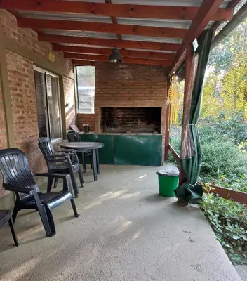a patio with chairs and a table and a fireplace at Árbol de Oro - Terrafirme in Villa Yacanto
