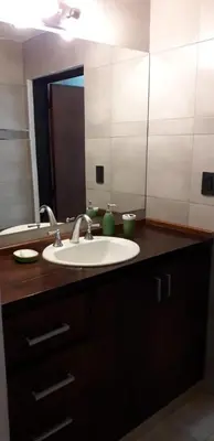 a bathroom with a sink and a large mirror at La Mexicana - Alta Gracia in Alta Gracia