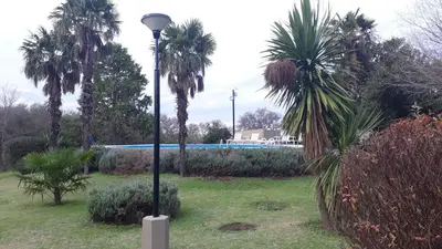 a street light in a park with palm trees at Hotel de Campo Posada la Esperanza in Río Cuarto