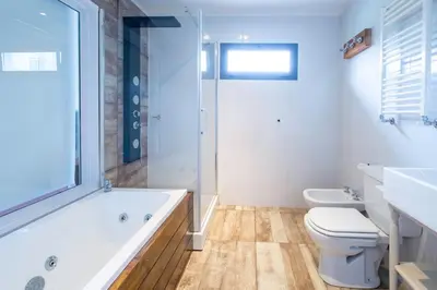 a bathroom with a tub and a toilet and a sink at Atelier Hotel de Charme in Villa General Belgrano