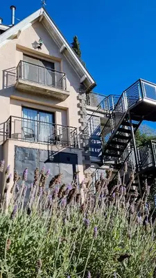 a building with stairs and flowers in front of it at Atelier Hotel de Charme in Villa General Belgrano