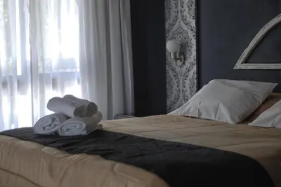a hotel room with a bed with towels on it at Atelier Hotel de Charme in Villa General Belgrano