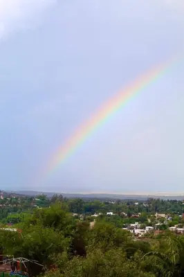 a rainbow in the sky over a city at Alto de Balcon B in Tanti