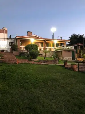 a large house with a lawn in front of it at CASA CON VISTA A LAS SIERRAS in Villa Carlos Paz