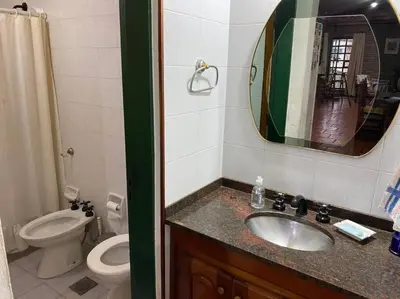 a bathroom with a sink and a toilet and a mirror at CASA CON VISTA A LAS SIERRAS in Villa Carlos Paz