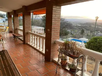 a balcony of a house with a view of a pool at CASA CON VISTA A LAS SIERRAS in Villa Carlos Paz