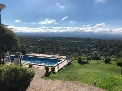 a villa with a swimming pool on a hill at CASA CON VISTA A LAS SIERRAS in Villa Carlos Paz