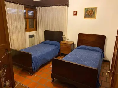 two beds in a room with blue sheets at CASA CON VISTA A LAS SIERRAS in Villa Carlos Paz