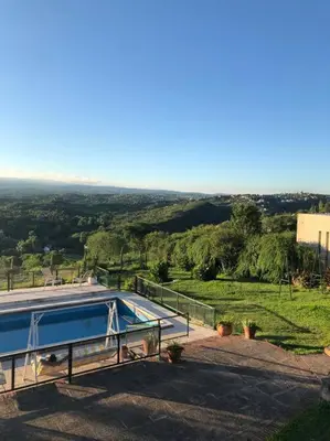 a house with a swimming pool on a hill at CASA CON VISTA A LAS SIERRAS in Villa Carlos Paz
