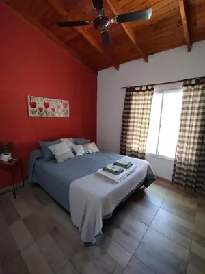 a bedroom with a bed with red walls and a ceiling at Complejo Serena in Santa Rosa de Calamuchita
