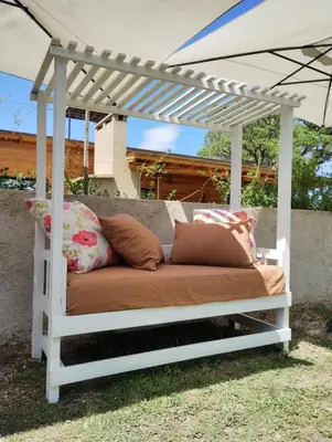 a bed under a white pergola with pillows at Complejo Serena in Santa Rosa de Calamuchita